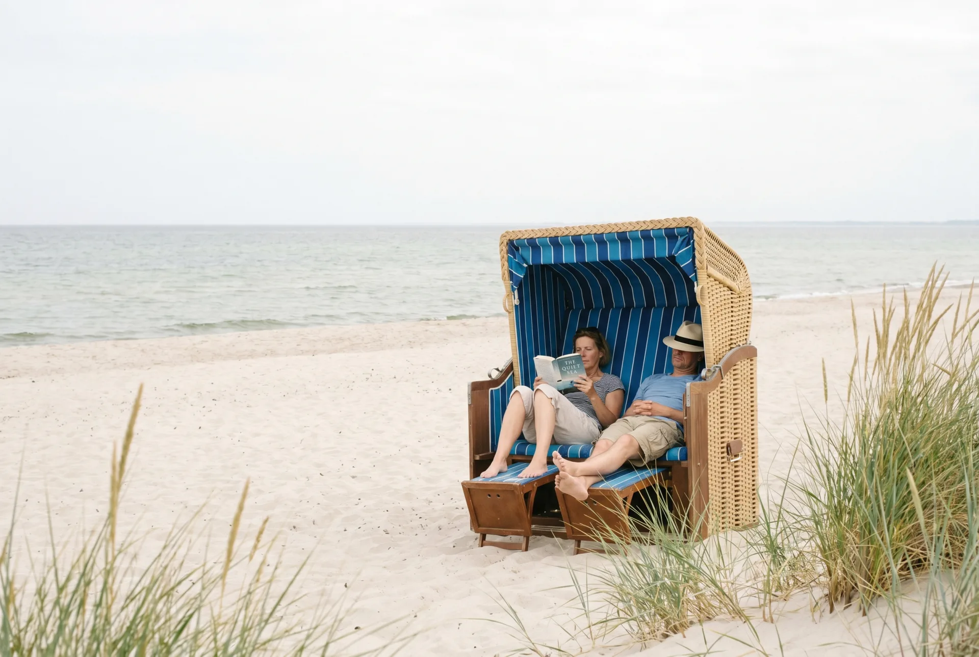 Paar liest im Strandkorb an der Ostsee